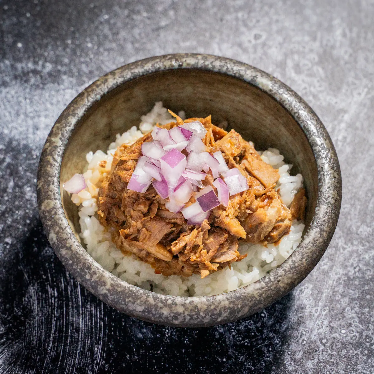 Chashu Rice Bowl - Rice bowl topped with cherrywood-smoked pork chashu, crisp red onion, and savory soy glaze