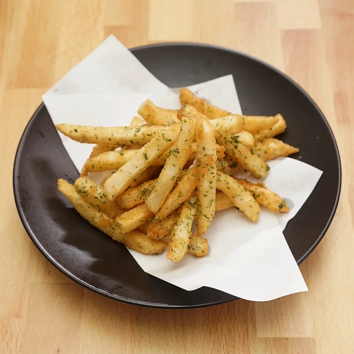 Gachi Fries - French fries tossed in signature burnt garlic oil, rice crispies, and parsley, vegan